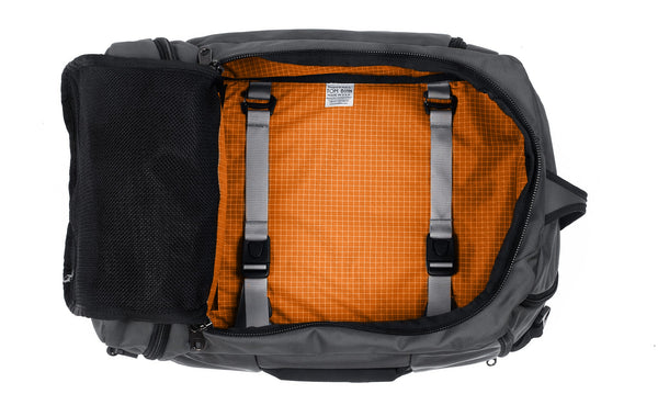 An open Techonaut 30 with a Nebulous Grey (dark grey) exterior and an Zest (orange) interior.